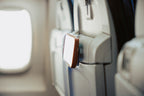 Clear Mo'Bettah Airplane Phone Holder holding an iPhone on an airplane seat pocket during a flight