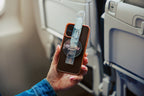 Traveler holding a Clear Mo'Bettah Airplane Phone Holder next to a MagSafe-compatible iPhone