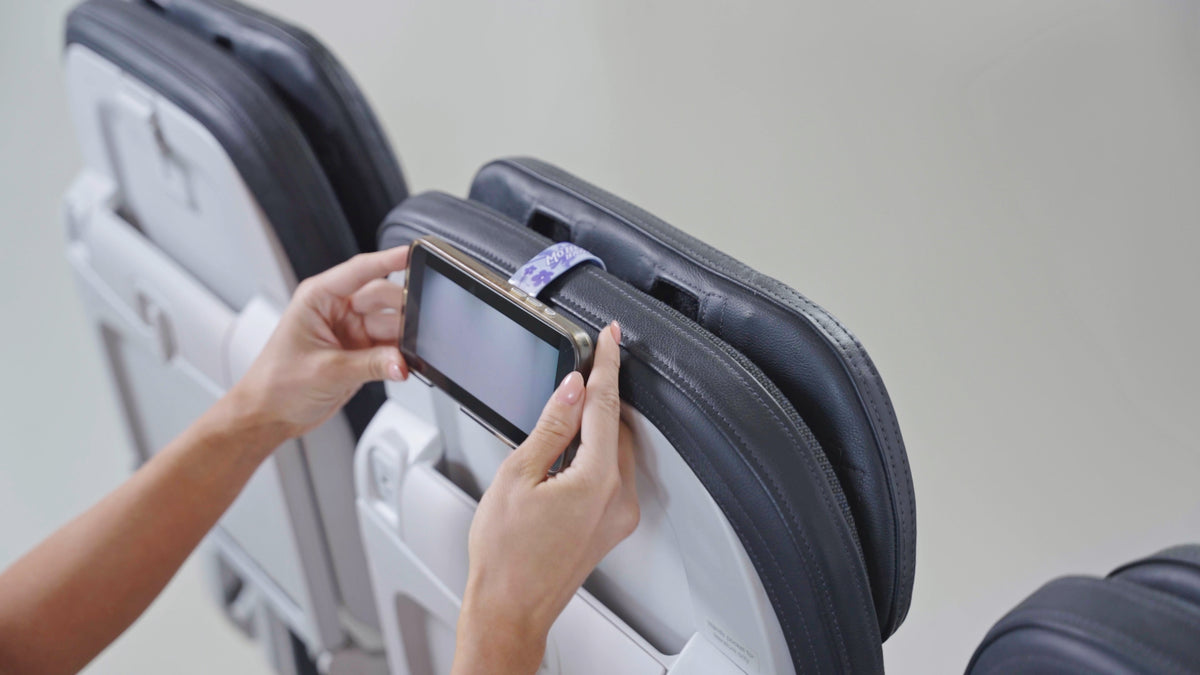 Mo'Bettah Airplane Phone Holder holding an iPhone on an airplane seat during a flight