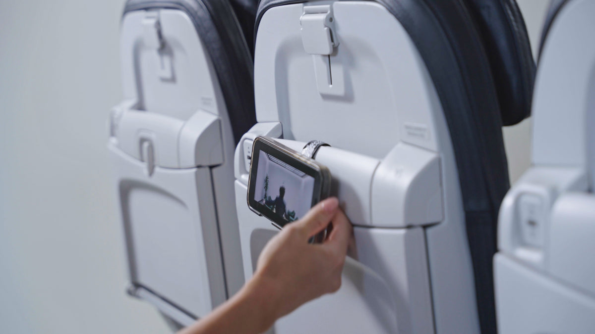 Mo'Bettah Airplane Phone Holder attached to an airplane seat pocket for hands-free entertainment