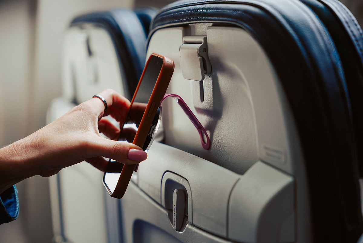 Hanging an iPhone from an airplane seat pocket using the Pink Mo'Bettah Airplane Phone Holder