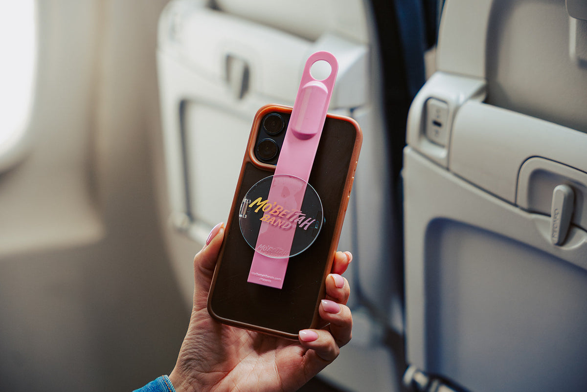 Pink Mo'Bettah Airplane Phone Holder securely attached to an iPhone